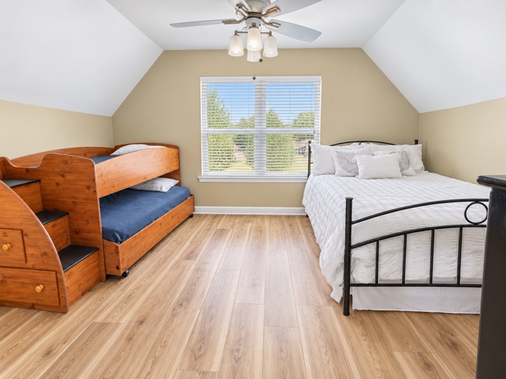 Bedroom with wooden bunks and a larger bed
